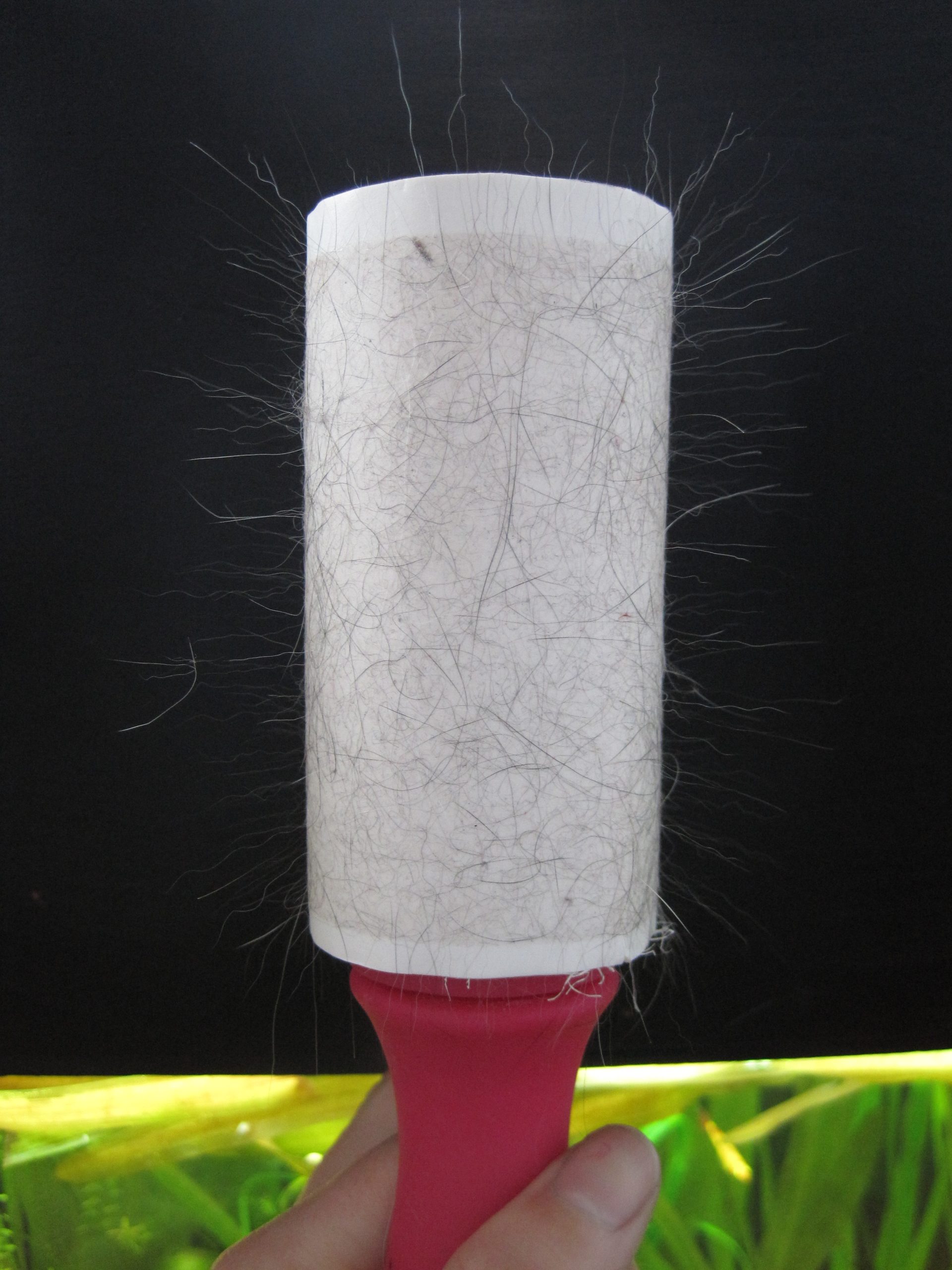 Scotch-Brite style lint roller removing pet hair from fabric
