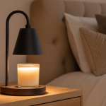 Generic candle warmer lamp glowing over an unlabeled candle jar on a bedside table