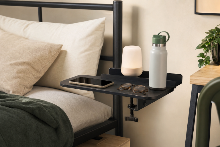 Generic clamp-on bedside shelf attached to a bed frame with everyday items